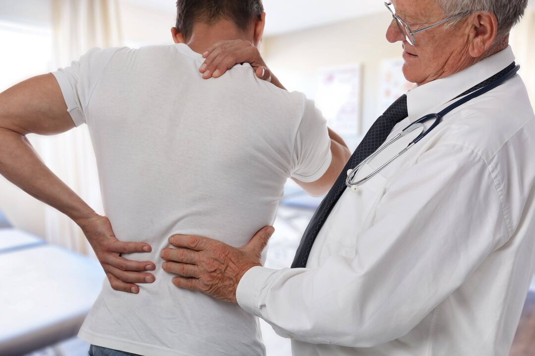gydytojas apžiūri pacientą, kenčiantį nuo nugaros skausmo