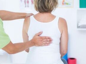 Pacientą, kuris skundžiasi nugaros skausmais pečių srityje, apžiūri gydytojas